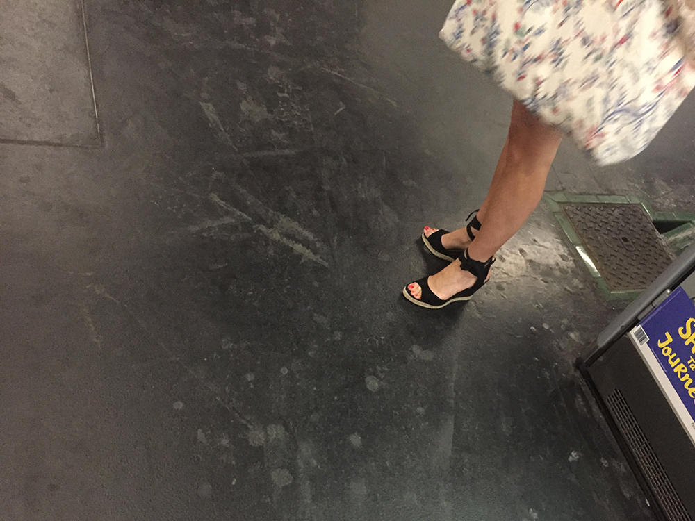 Une femme en sandales sexy attend le métro