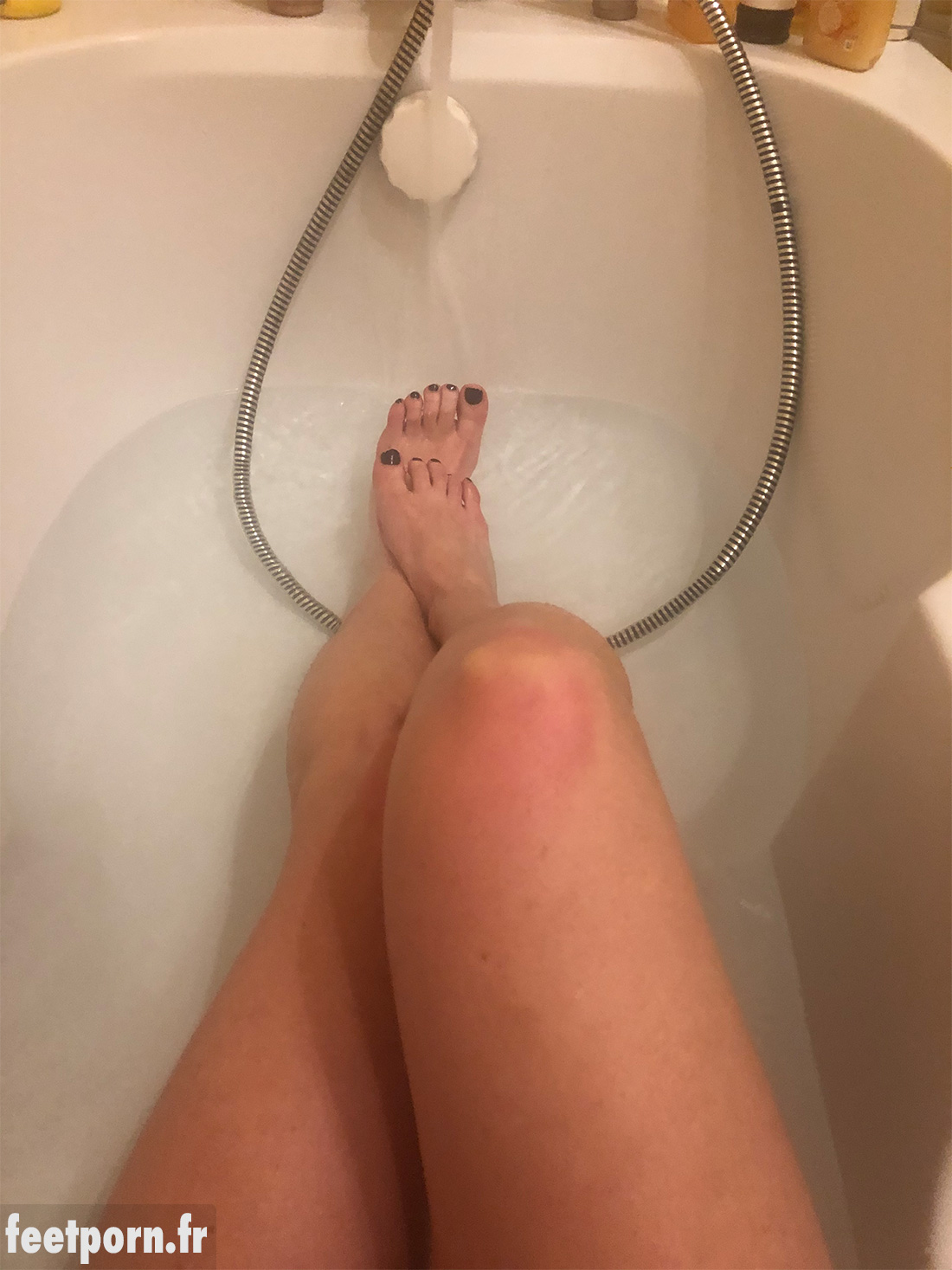 Une femme mature exhibe ses pieds dans son bain