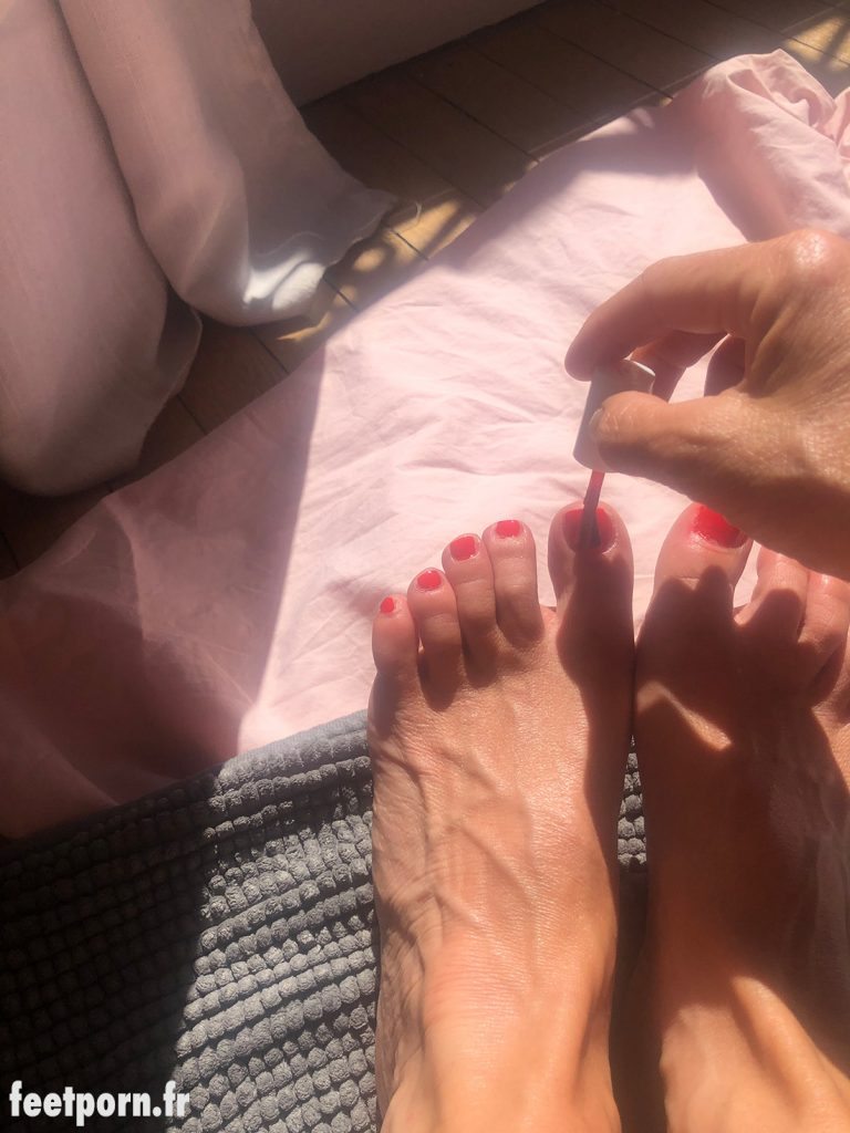 Elle se vernit en rouge les ongles des pieds